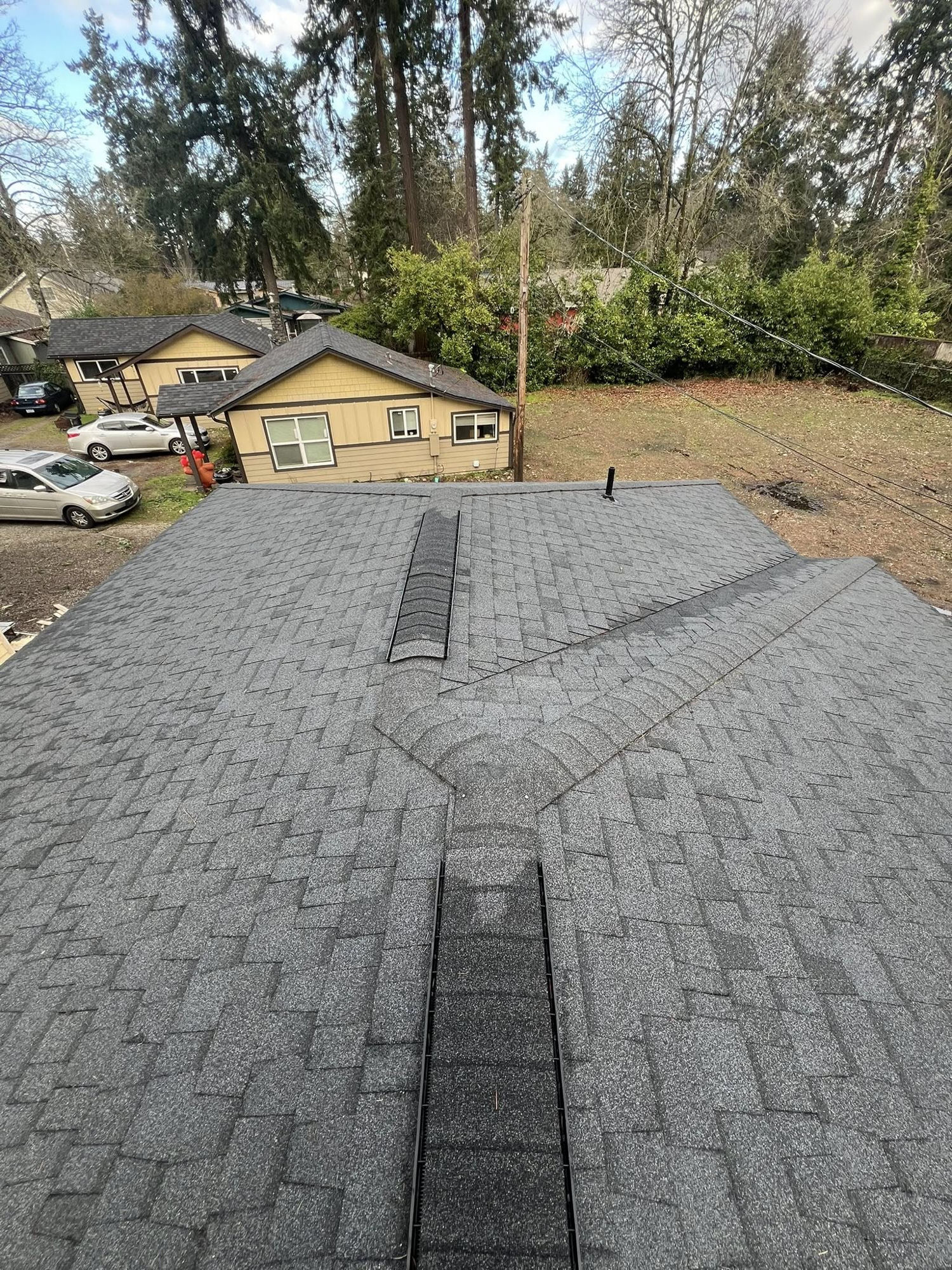 Completed architectural shingle roof with ridge vent and valley flashing in Tacoma, WA